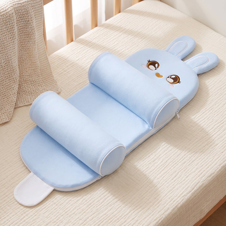 Dukaano baby positioning pillow laid out on a bed